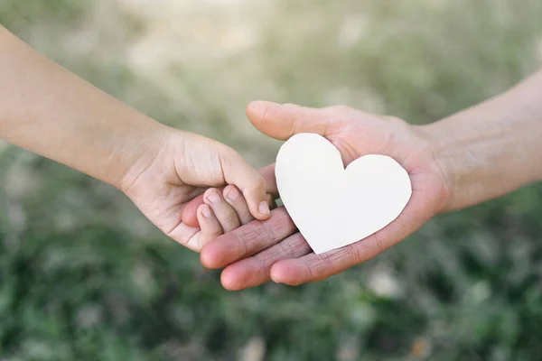 Childs mano y vieja mano abuela celebrar el corazón. — Foto de Stock