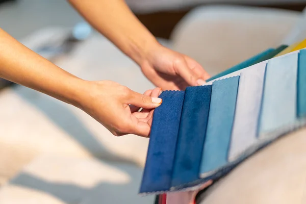 Die Frau wählt den Stoff auf dem Sofa. Hintergrund der Textilindustrie. Gewebekatalog — Stockfoto