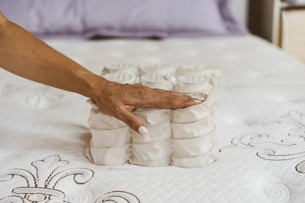 Materiale del materasso nelle mani di una donna. Molla indipendente tascabile. — Foto Stock