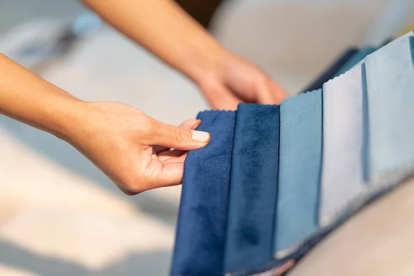 La mujer elige la tela en el sofá. Fondo de la industria textil. Catálogo de tejidos — Foto de Stock