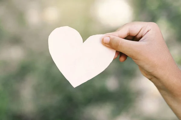 La mano del niño sostiene un corazón. Concepto de protección de los niños, amistad, unión — Foto de Stock