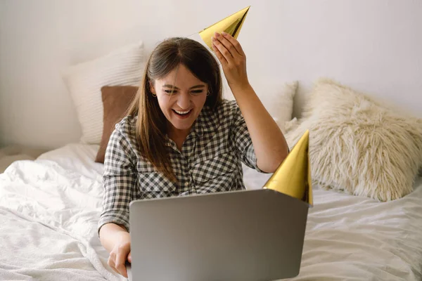 Hermosa chica celebrando cumpleaños en línea en tiempo de cuarentena a través de videollamada fiesta virtual con amigos. — Foto de Stock