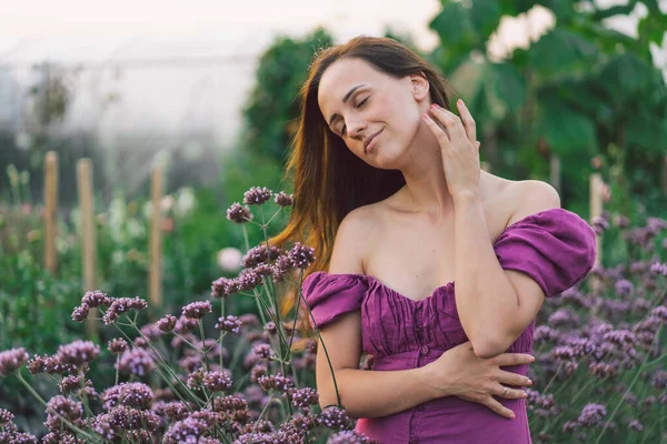 Chica retrato con pelo largo en flores púrpuras. Camina por el jardín de flores. Chica y flores — Foto de Stock