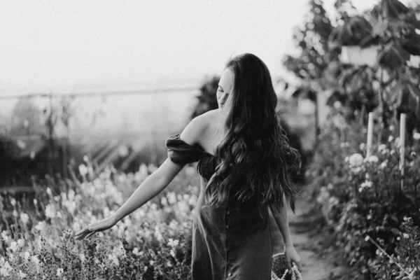 Ritratto ragazza con i capelli lunghi con un cesto di fiori. Passeggiata nel giardino fiorito. Ragazza e fiori — Foto Stock