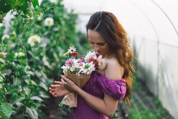 Porträtt flicka med långt hår i växthuset. Går i blomsterträdgården. Flicka och blommor — Stockfoto