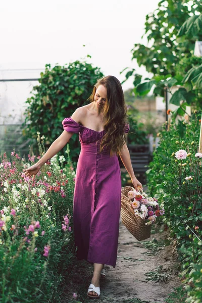 Menina retrato com cabelos longos com uma cesta de flores. Caminhe no jardim das flores. Menina e flores — Fotografia de Stock