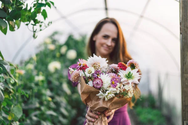 La chica sostiene un ramo en sus manos. El ramo está enfocado. Arreglo floral. — Foto de Stock