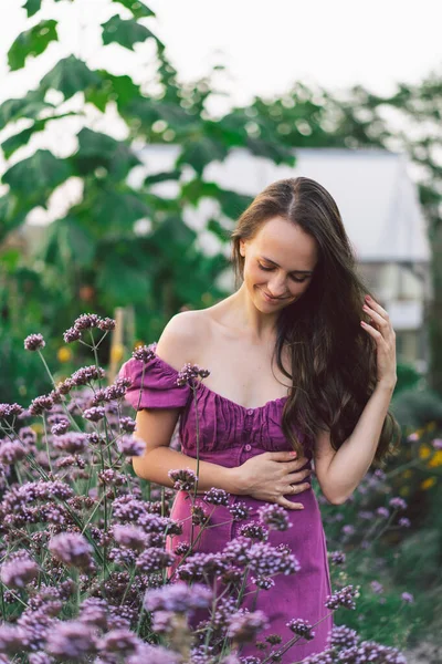 Portrait girl with long hair in purple flowers. Walk in the flower garden. Girl and flowers — Stock Photo, Image