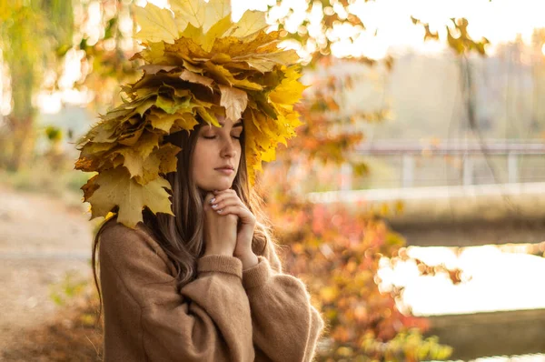 Young woman with a wreath of yellow autumn leaves. Outdoors portrait. — Stock Photo, Image