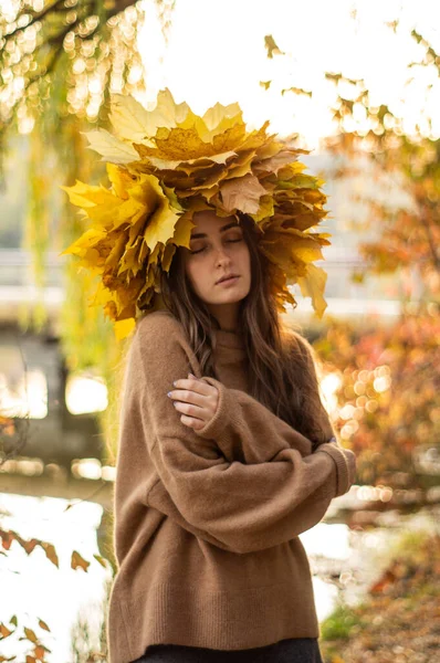 Jeune femme avec une couronne de feuilles d'automne jaunes. Portrait extérieur. — Photo