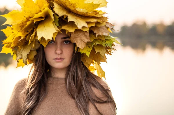 Junge Frau mit einem Kranz aus gelben Herbstblättern. Außenporträt. — Stockfoto