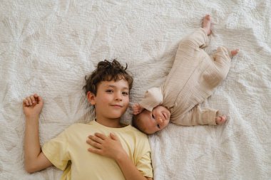 Two little boys brothers enjoying playing in cozy bright bedroom, smiling and playing. Happy childhood. Children portraits.