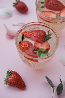 Pembe bir arka plan üzerinde çilek sodalı. İçki serinletici yaz. Üstten görünüm