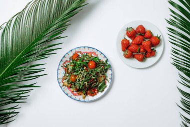 Roket salata ve beyaz zemin üzerine domates salatası. Üstten Görünüm, düz yatıyordu