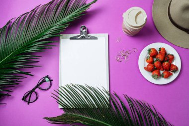 Çalışma alanı: pano, palmiye yaprağı, kahve ve şapka mor bir arka plan üzerinde. Üstten Görünüm, düz yatıyordu, metin için yer