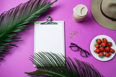 Çalışma alanı: pano, palmiye yaprağı, kahve ve şapka mor bir arka plan üzerinde. Üstten Görünüm, düz yatıyordu, metin için yer