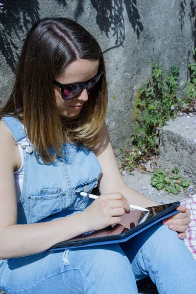 Hipster 선글라스에서 야외에서 태블릿에 그립니다 — 스톡 사진
