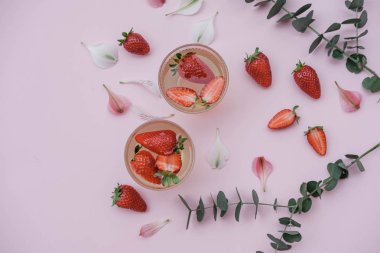Pembe bir arka plan üzerinde çilek sodalı. İçki serinletici yaz. Üstten görünüm