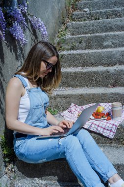 Genç Sarışın hipster kadın freelancer dizüstü yaz gün açık havada çalışan güneş gözlüğü
