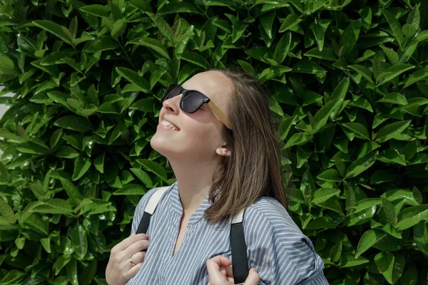 Jonge Lachende Vrouw Zonnebril Met Een Rugzak Een Groene Natuurlijke — Stockfoto