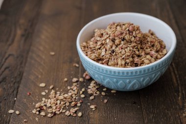 Ahşap arka plan üzerinde fındık ile ev yapımı Granola mavi kase pişmiş 