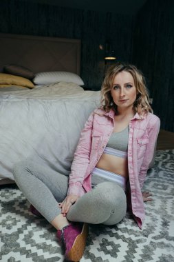 Evde yeşil tişört giyen genç gülen sarışın kadın portresi