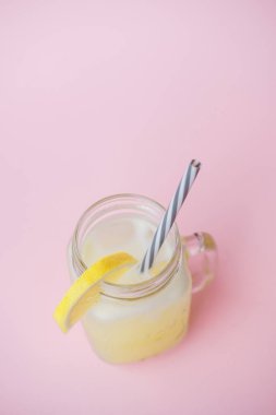 Meyve suyu limon pembe bir arka plan üzerinde cam kavanozda