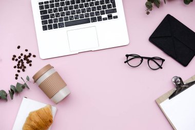 Serbest meslek ev ofis resepsiyon çalışma dizüstü bilgisayar ve battaniye. Sabah kahvaltı kahve ve kruvasan üzerinde pembe bir arka plan ile. Düz yatıyordu, en iyi görünümü natürmort kavramı