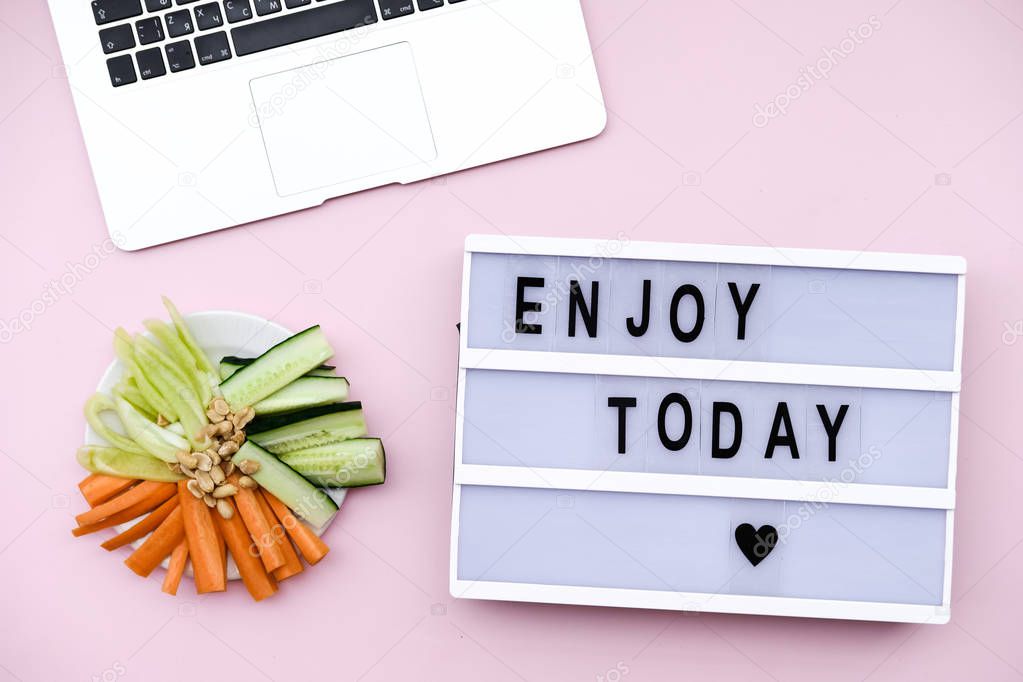 Letter Board Quote with laptop and  healthy vegetable snack on pink background. Flat lay, top view still life concept