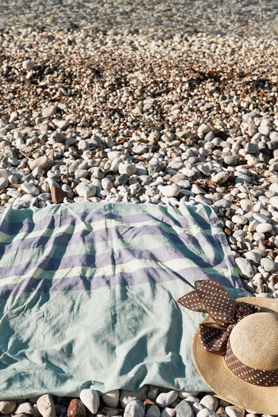 Kompozycja Lato Kapelusz Zielony Ręcznik Kamienistą Plażą Pobliżu Morza — Zdjęcie stockowe