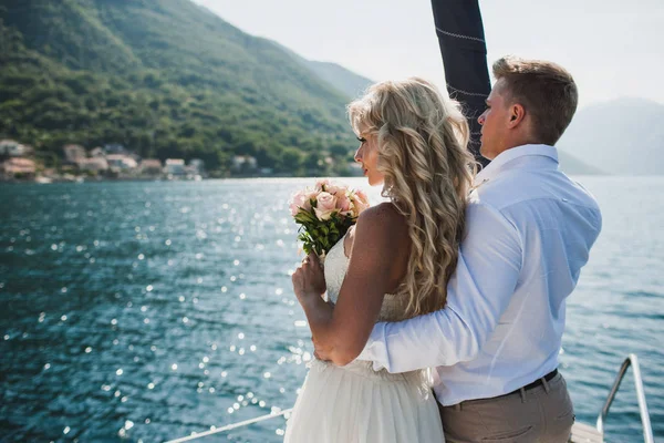 美丽的时尚新娘和新郎在豪华游艇上航行在他们的婚礼大海上 — 图库照片