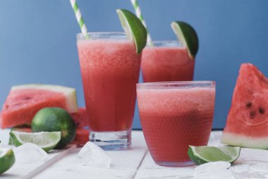 Smoothies taze karpuz, kireç buz üzerinde mavi arka plan ile