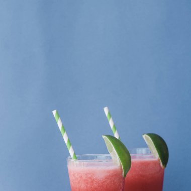 Smoothies taze karpuz, kireç buz üzerinde mavi arka plan ile. Metin için yer