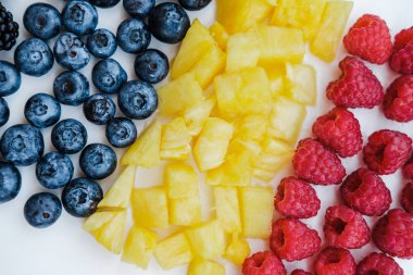 «Ana sayfa» gökkuşağı renkleri, ananas, böğürtlen, yaban mersini ve ahududu nane ile sağlıklı meyveleri görünümünü kapalı beyaz üzerine tablo, düz yatıyordu