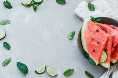 Karpuz dilimleri nane, limon ve böğürtlen içinde yaz gri bir arka plan üzerinde bir plaka üzerinde çerçeve. Üstten görünüm, kopya alanı