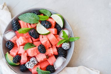 Karpuz dilimleri, Dondurulmuş böğürtlen ve kireç beyaz arka plan üzerinde bir tabakta gelen meyve salatası. Üstten görünüm, kopya alanı