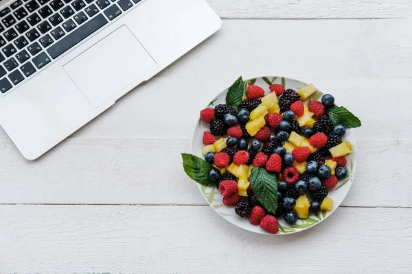 Pracovní Prostor Notebookem Zdravé Bobule Barvách Duhy Ananas Ostružiny Borůvky — Stock fotografie