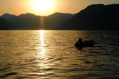 Akdeniz'in dağlar çerçevede batan güneşin ışınları içinde yat 