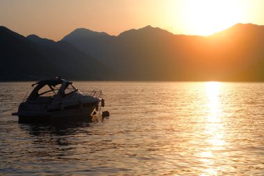 Akdeniz'in dağlar çerçevede batan güneşin ışınları içinde yat 