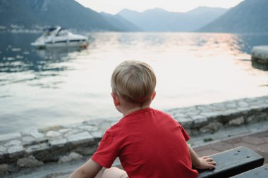 Kırmızı T-shirt denizde batımını Karadağ'ın küçük çocuk arkadan görünüm