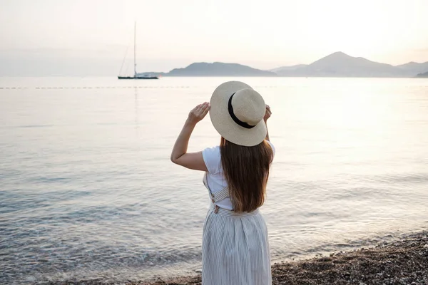 Vista Trasera Una Joven Hermosa Mujer Sosteniendo Sombrero Paja Playa — Foto de Stock