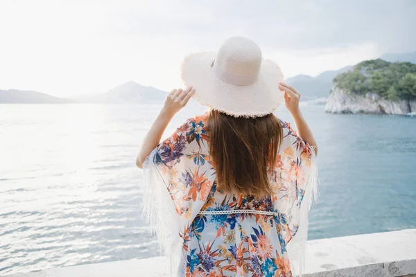 Achteraanzicht Van Een Jonge Mooie Vrouw Houdt Haar Stro Hoed — Stockfoto