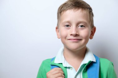 Beyaz zemin üzerinde mavi sırt çantası ile sevimli bir öğrenci portresi