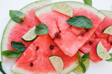 Karpuz dilimleri ve kireç beyaz arka plan üzerinde bir tabakta. Üstten görünüm