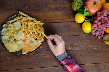 Fast food ve meyve ahşap arka plan üzerinde. Üstten görünüm, kopya alanı