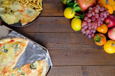 Fast food ve meyve ahşap arka plan üzerinde. Üstten görünüm, kopya alanı