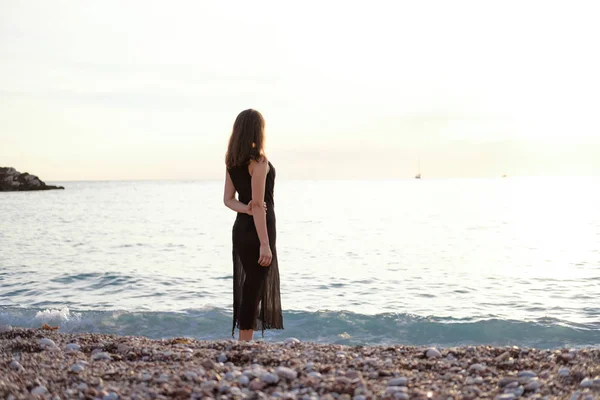 Parte Posterior Una Joven Con Vestido Negro Mirando Mar Atardecer — Foto de Stock