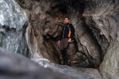 Genç Explorer'da bir mağarada ekipman eylem için hazır tırmanma siyah spor giyim