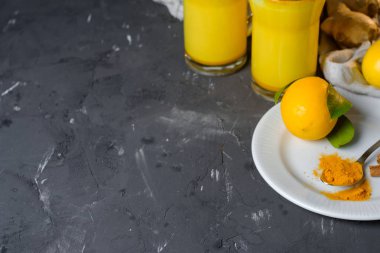 Zerdeçal latte veya gözlük zencefil ve limon siyah bir tablo ile altın süt. Kopya alanı