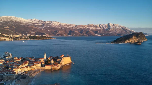 Budva, Karadağ, gün batımı ve karla kaplı dağlar'ın eski şehir görünümünü